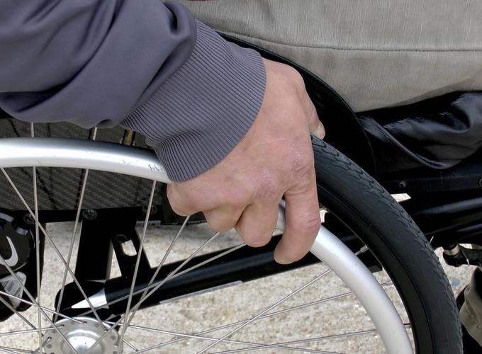 Closeup picture of a wheelchair users hand on wheel