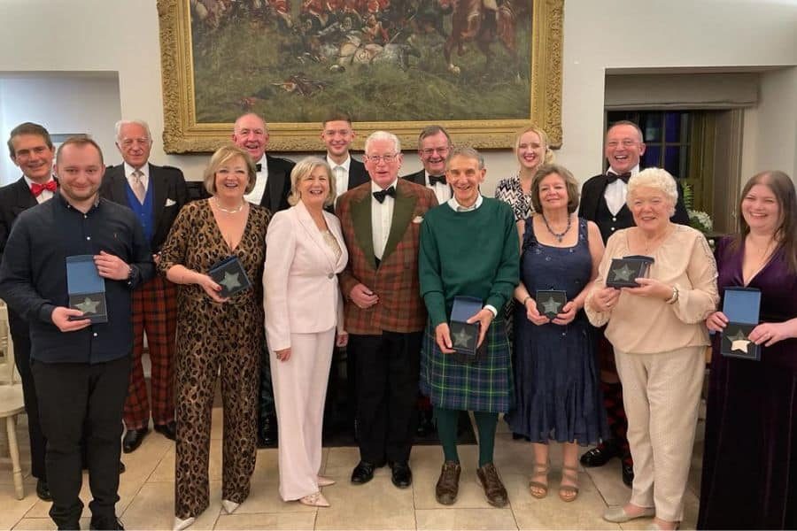 group of 15 staff and volunteers at the Balhousie Castle holding their awards